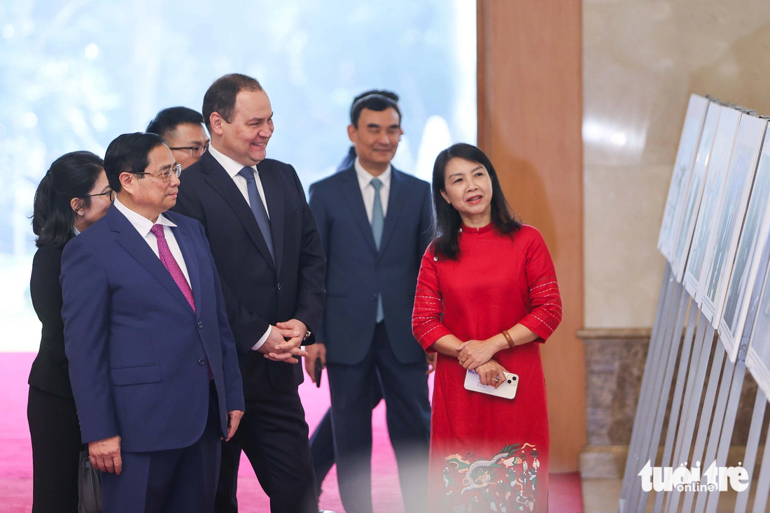 Thủ tướng Phạm Minh Chính và Thủ tướng Belarus Roman Golovchenko xem triển lãm ảnh về quan hệ hai nước - Ảnh: NGUYỄN KHÁNH
