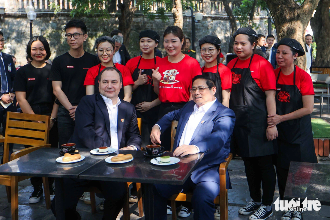 Thủ tướng Phạm Minh Chính và Thủ tướng Belarus Roman Golovchenko chụp ảnh cùng các nhân viên quán cà phê - Ảnh: NGUYỄN KHÁNH