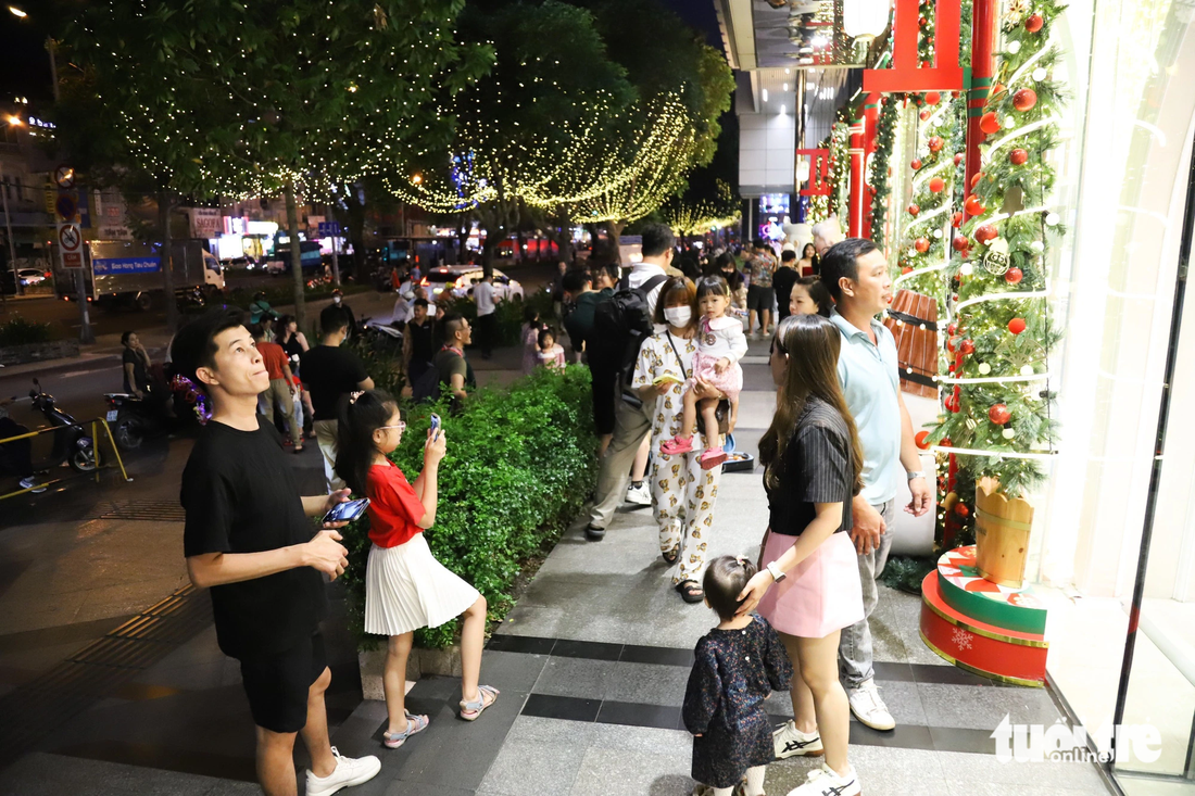 Hàng cây thông trang trí dọc trung tâm thương mại trên đường Lê Lợi (quận 1) thu hút đông đảo người dân đến tham quan tối 9-12