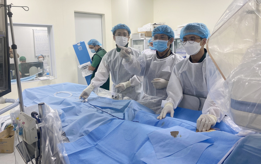 Bác sĩ Đỗ Nguyên Tín (giữa) đang thực hiện ca can thiệp cho một bệnh nhân tim bẩm sinh mà ông phát hiện từ đợt khám từ thiện hồi tháng 12-2022. Ca can thiệp này diễn ra tại Bệnh viện Đa khoa tỉnh Khánh Hòa vào ngày 24-2. Hôm nay (25-2) ông lại cùng cộng sự khám sàng lọc bệnh tim miễn phí cho trẻ em và bà con nghèo huyện Sông Hinh, tỉnh Phú Yên - Ảnh: N.T.