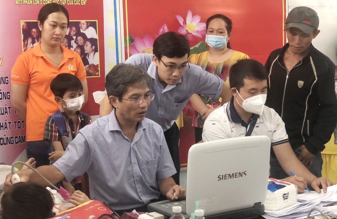 Bác sĩ Đỗ Nguyên Tín (trái) khám tầm soát bệnh tim bẩm sinh cho trẻ em nghèo tại xã Thạch Ngãi, huyện Mỏ Cày Bắc, tỉnh Bến Tre, vào tháng 10-2022  - Ảnh: P.S.