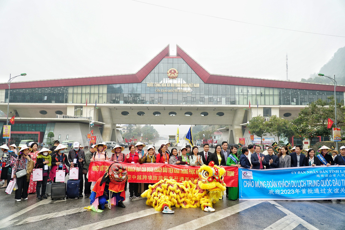 Đoàn khách du lịch Trung Quốc đầu tiên đến Việt Nam sau dịch COVID-19 được tặng hoa, quà lưu niệm và nón lá khi qua cửa khẩu Hữu Nghị - Ảnh: NGUYỄN HIỀN