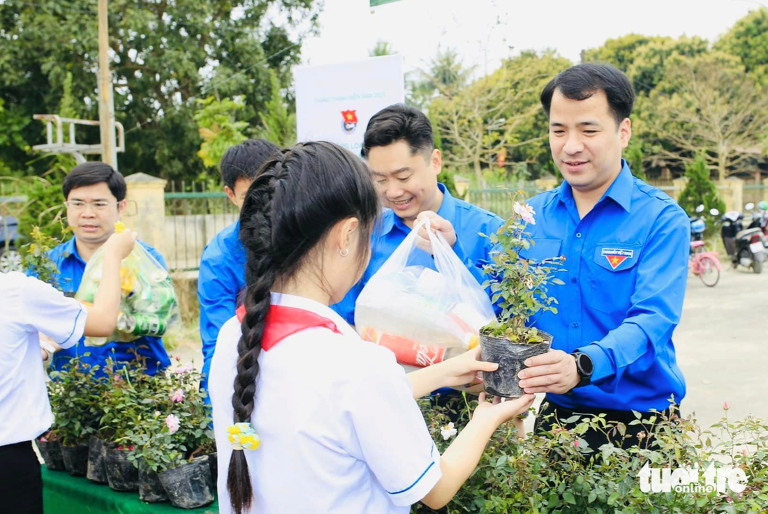 Anh Ngô Văn Cương - bí thư Trung ương Đoàn - trao cây xanh cho các bạn học sinh - Ảnh: DOÃN HÒA