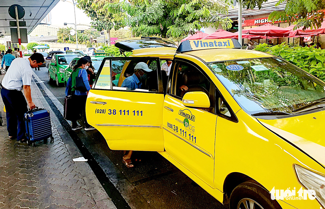 Hành khách đón taxi tại làn C sân bay Tân Sơn Nhất vào chiều 22-3 - Ảnh: CÔNG TRUNG