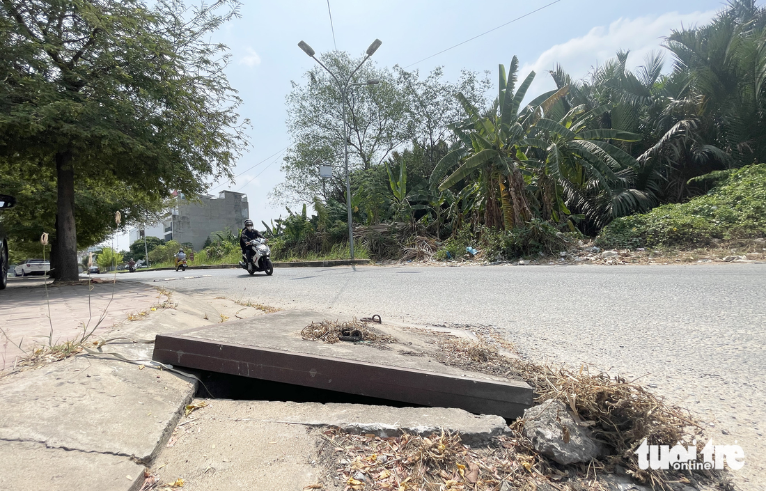Một nắp cống bị cạy vênh lên nằm ngay khúc cua trong khu đô thị An Phú - An Khánh, TP Thủ Đức gây nguy hiểm cho người đi đường - Ảnh: LÊ PHAN