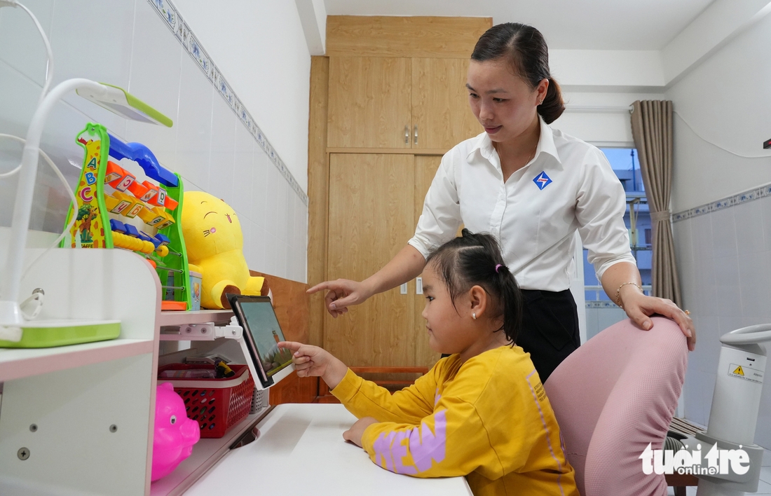 Chị Tạ Thị Trang, căn hộ ALB-04-46, chung cư Lê Thành (TP.HCM) hướng dẫn con học - Ảnh: HỮU HẠNH