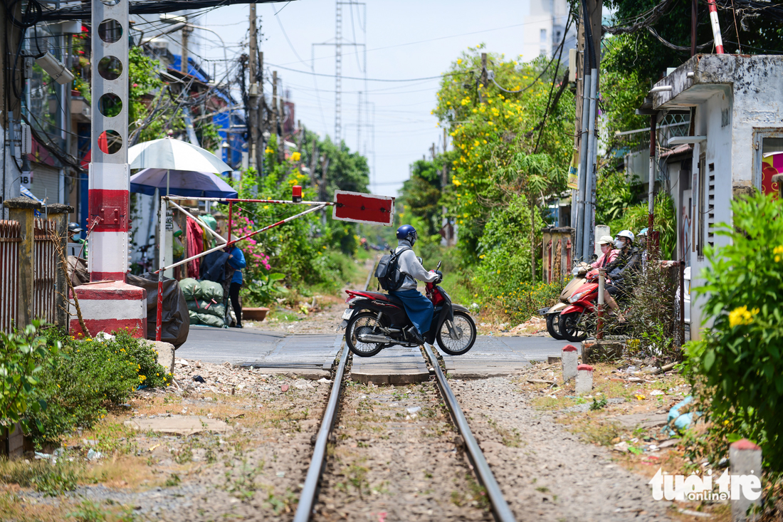 Dọc theo tuyến đường xe lửa được trang trí rào chắn, trông hoa tạo cảnh quan và an toàn (quận 3, TP.HCM)