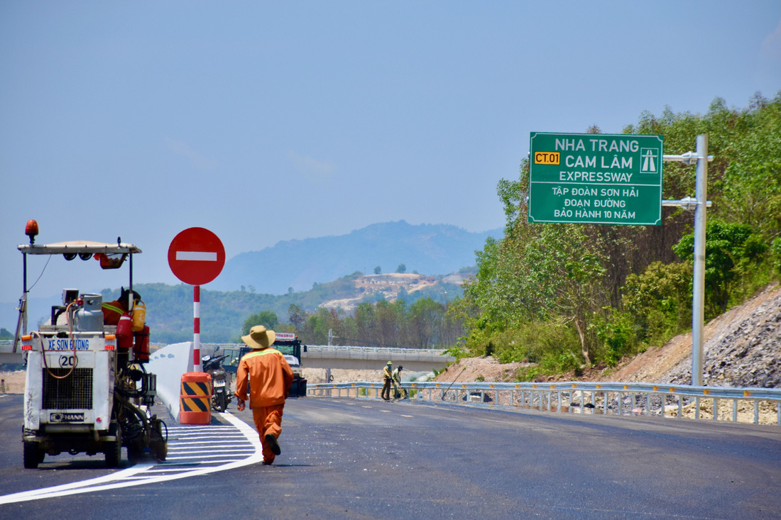 Tại điểm đầu vào cao tốc Nha Trang - Cam Lâm, công nhân vẫn còn thi công mặt đường - Ảnh: MINH CHIẾN