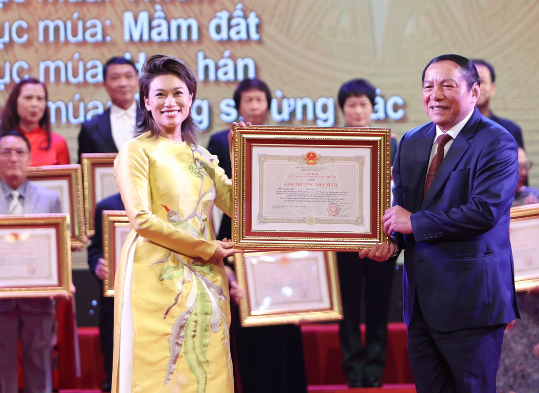 Bộ trưởng Bộ Văn hóa, Thể thao và Du lịch Nguyễn Văn Hùng trao giải thưởng Nhà nước cho NSƯT Trần Ly Ly - quyền cục trưởng Cục Nghệ thuật Biểu diễn - Ảnh: NGUYỄN KHÁNH 
