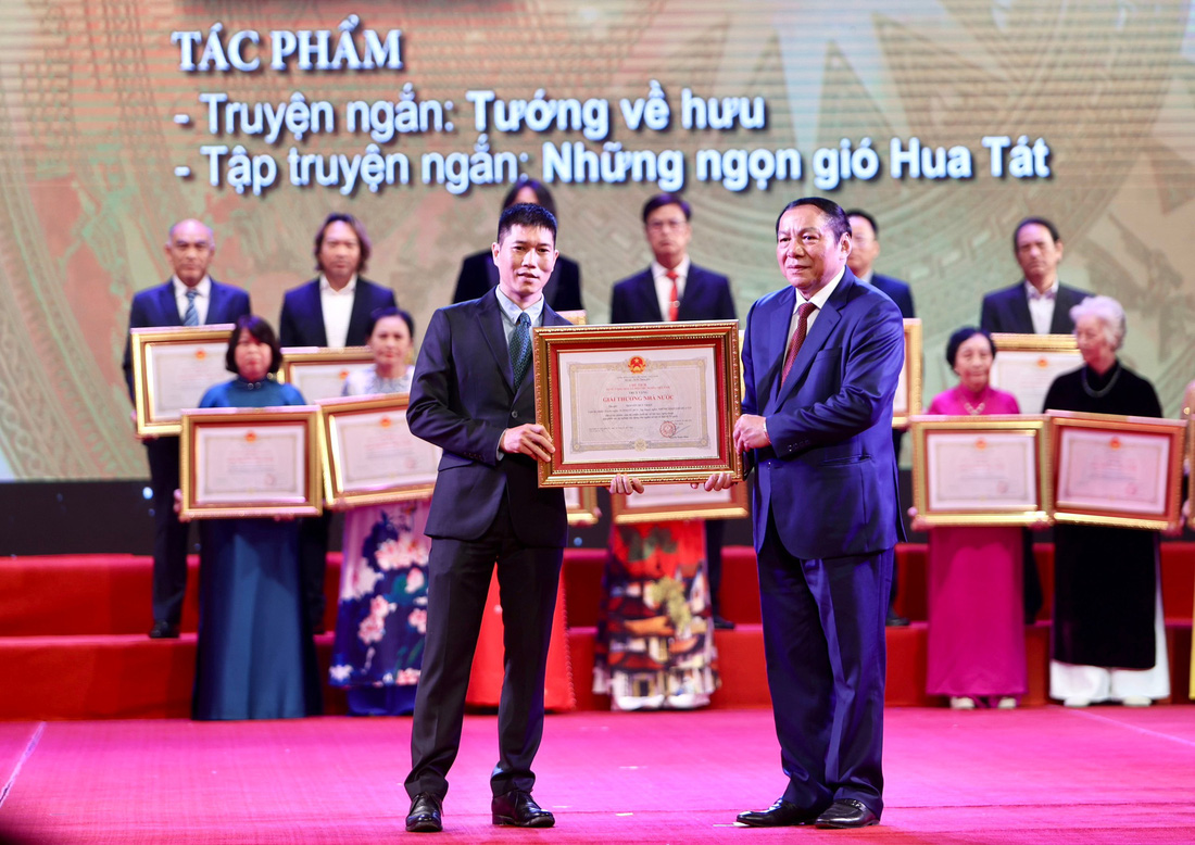 Họa sĩ Nguyễn Phan Bách (trái) - trưởng nam của nhà văn Nguyễn Huy Thiệp - nhận Giải thưởng Nhà nước được trao cho bố mình - Ảnh: NGUYỄN KHÁNH 