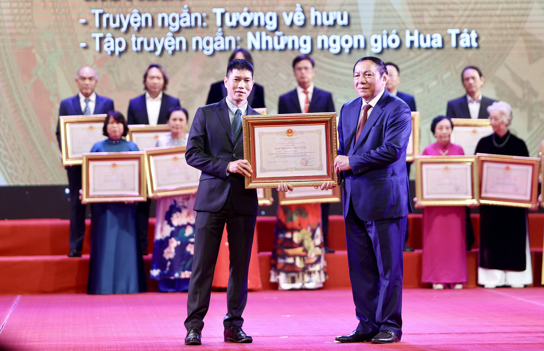 Họa sĩ Nguyễn Phan Bách (trái), trưởng nam của nhà văn Nguyễn Huy Thiệp, nhận Giải thưởng Nhà nước được trao cho cha mình  - Ảnh: NGUYỄN KHÁNH