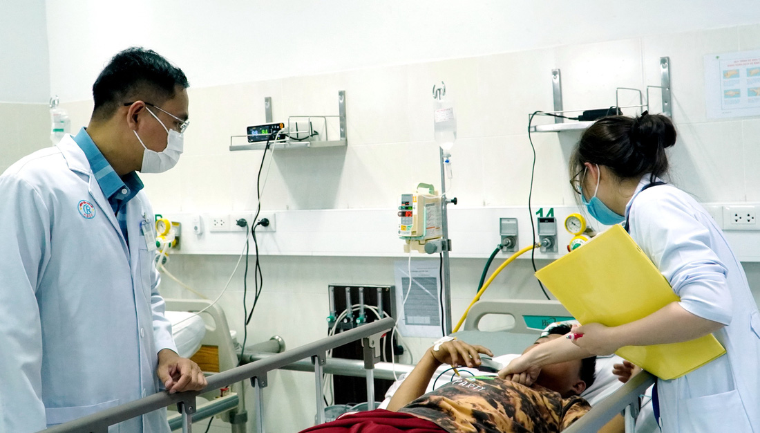 Bác sĩ Nguyễn Văn Thuận, khoa bệnh nhiệt đới Bệnh viện Chợ Rẫy, cùng bác sĩ Bệnh viện Nhi đồng 2 thăm khám cho một trong ba bệnh nhi nghi ngộ độc botulinum - Ảnh: BVCR cung cấp