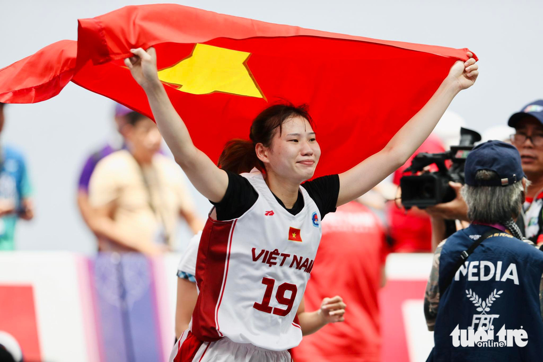 Tuyển thủ nữ bóng rổ Việt Nam giương cao quốc kỳ ăn mừng chiến thắng lịch sử - Ảnh: N.K