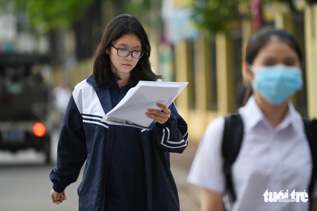 Thí sinh tranh thủ ôn bài trước khi vào phòng thi - Ảnh: NAM TRẦN