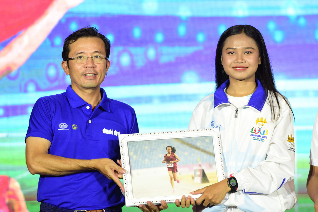 Ông Trần Xuân Toàn - Phó tổng biên tập báo Tuổi Trẻ - trao quà lưu niệm cho Bou Samnang - Ảnh: DUYÊN PHAN