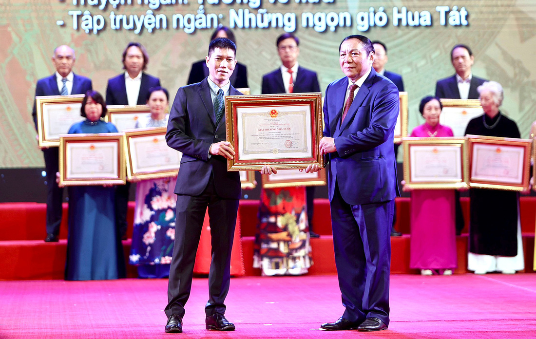 Con trai cố nhà văn Nguyễn Huy Thiệp (trái) nhận Giải thưởng Nhà nước cho cha mình  - Ảnh: NGUYỄN KHÁNH