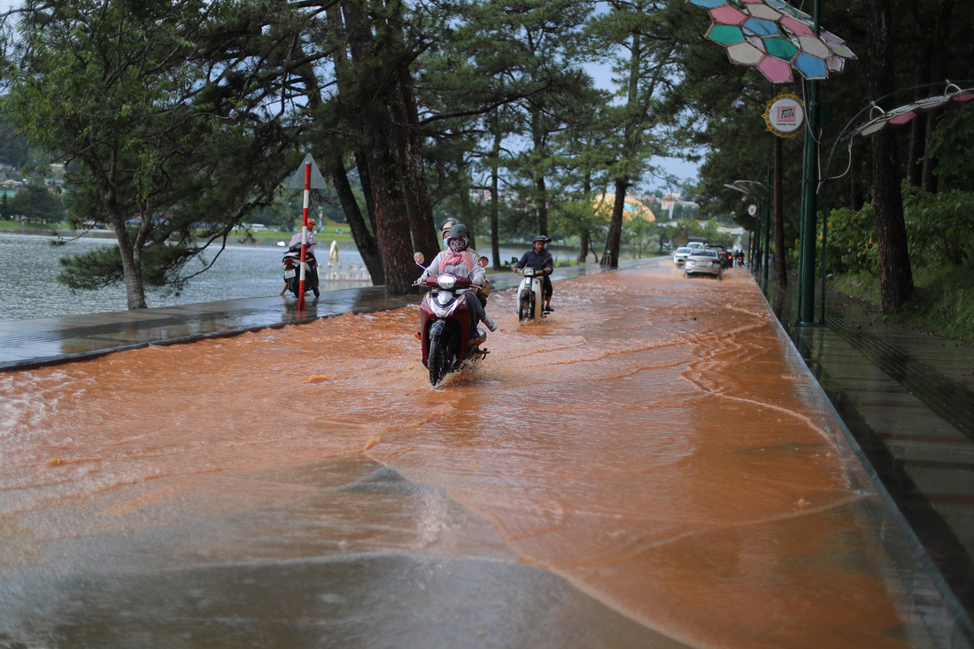 Nước đỏ quạch từ sân golf Đồi Cù chảy ra đường Trần Quốc Toản trước khi thoát ra hồ Xuân Hương - Ảnh: M.V.