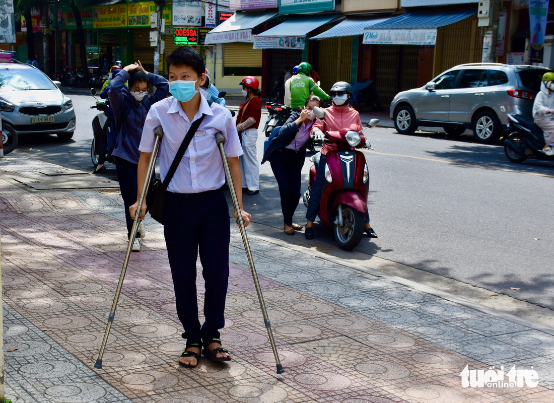 Bị đau chân, Nguyễn Duy Bảo, có mặt tại điểm thi THPT Lý Tự Trọng từ sớm. Tuy phải chống nạng khá bất tiện, em cho biết mình tự tin vì đã ôn bài khá đầy đủ - Ảnh: MINH CHIẾN