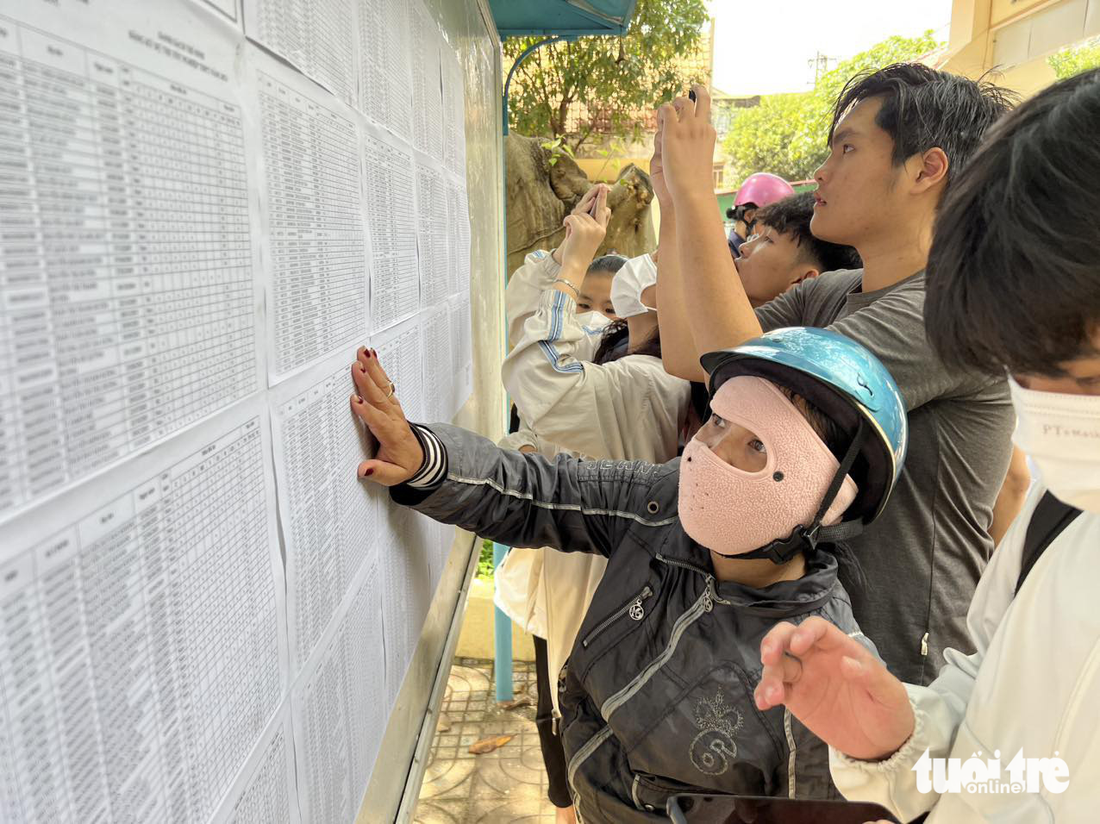Một phụ huynh xem số báo danh cho con tại điểm thi Trường THPT Hồng Đức, TP Buôn Ma Thuột, Đắk Lắk - Ảnh: MINH PHƯƠNG