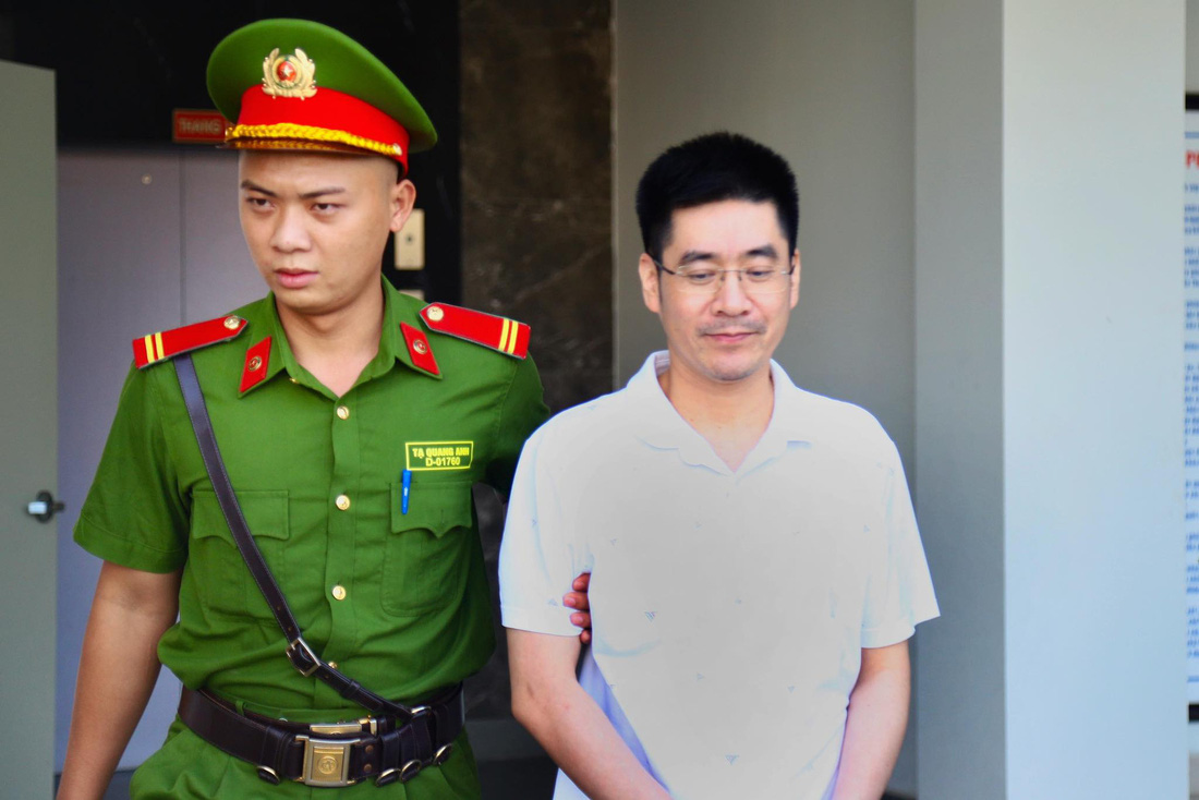 Cựu trưởng phòng an ninh Hoàng Văn Hưng được dẫn giải đến phiên tòa xử vụ chuyến bay giải cứu - Ảnh: DANH TRỌNG