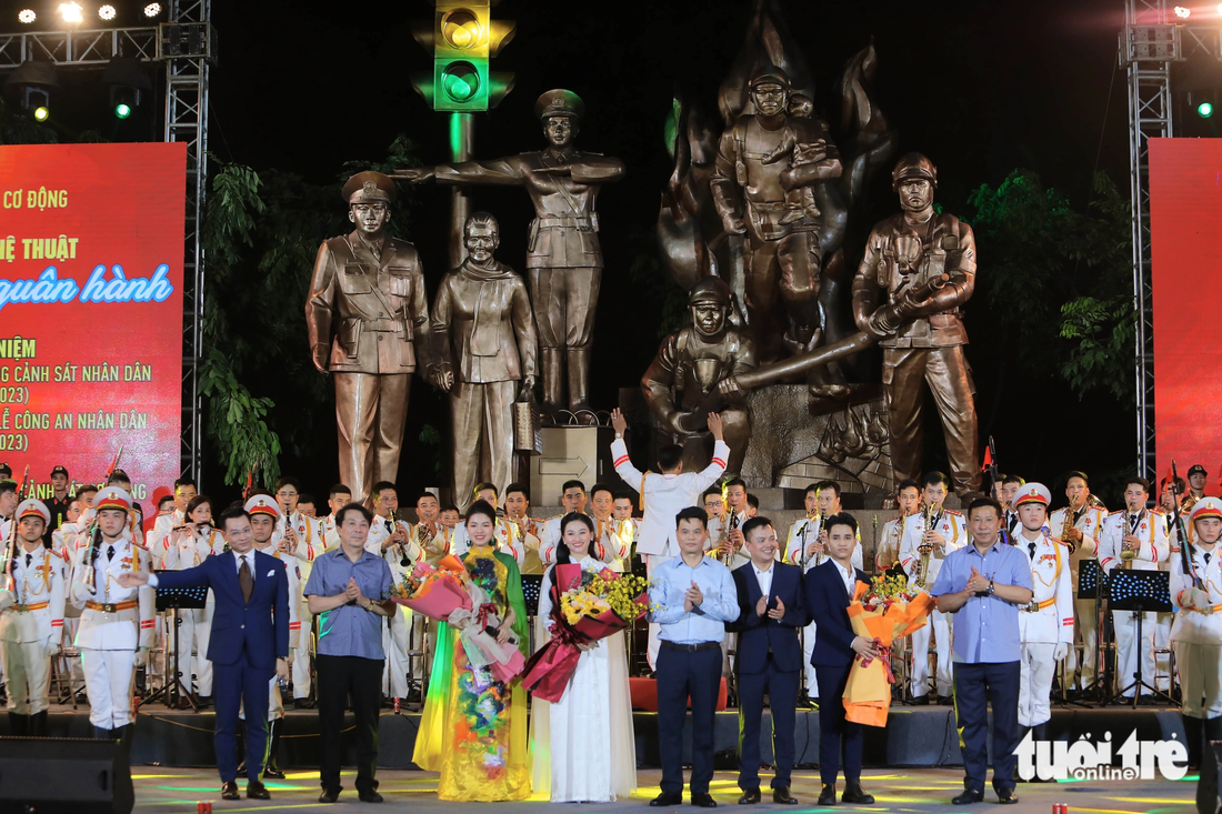 Đại biểu tặng hoa cho nghệ sĩ, diễn viên và các chiến sĩ tham gia chương trình “Vang mãi khúc quân hành” do Bộ Tư lệnh Cảnh sát cơ động tổ chức - Ảnh: DANH KHANG