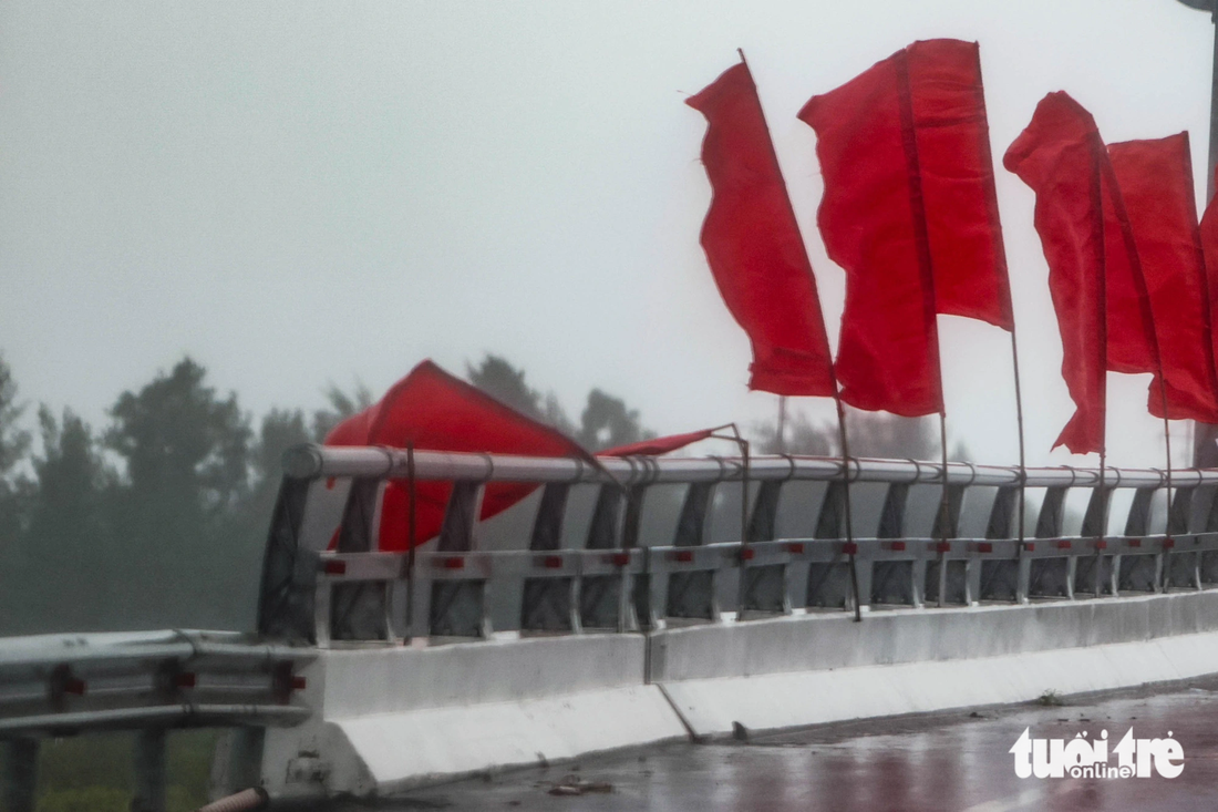 Gió bão làm gãy cờ treo trên một cây cầu ở thành phố Móng Cái - Ảnh: NGUYỄN KHÁNH