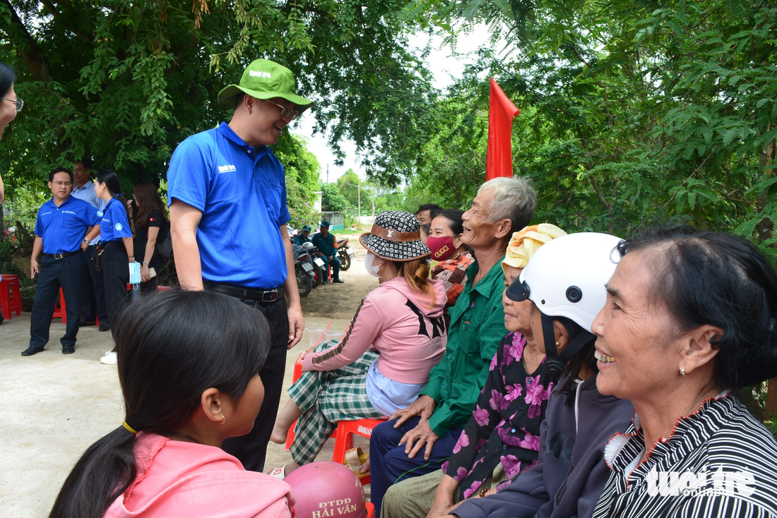 Ông Nguyễn Hồ Hải - phó bí thư Thành ủy TP.HCM (áo xanh) - thăm hỏi bà con trên tuyến đường quê xã Tân Hộ Cơ trước lễ khánh thành.