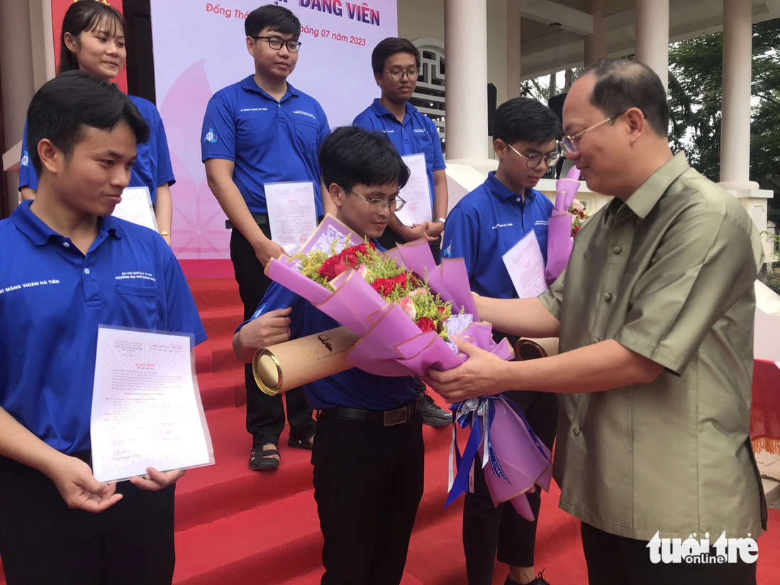 Ông Nguyễn Hồ Hải - phó bí thư Thành ủy TP.HCM - tặng hoa cho đảng viên mới.