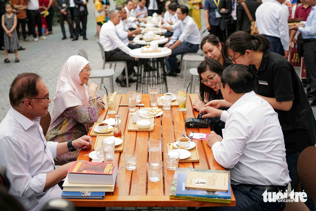 Thủ tướng Phạm Minh Chính quẹt thẻ thanh toán tiền cà phê cho bàn của mình trước khi ra về - Ảnh: NGUYỄN KHÁNH