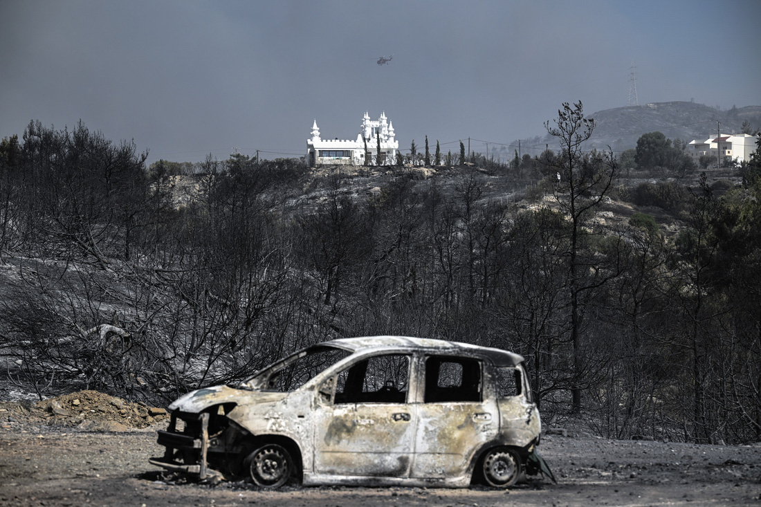 Một chiếc ô tô cháy trơ khung sau đám cháy ở gần làng Kiotari, đảo Rhodes - Ảnh: AFP