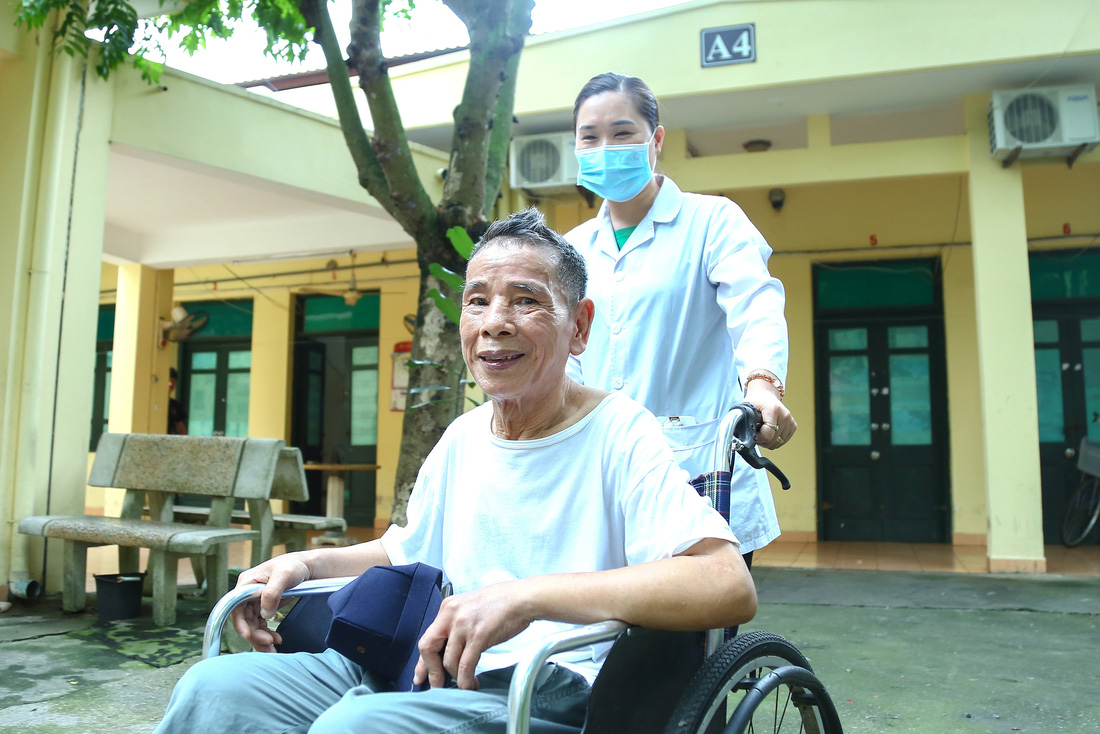 Hằng ngày, điều dưỡng Nguyễn Thị Hương dành thời gian để đi dạo, chia sẻ các câu chuyện trong cuộc sống cùng các bác thương binh tại Trung tâm điều dưỡng thương binh Thuận Thành, Bắc Ninh - Ảnh: HÀ QUÂN