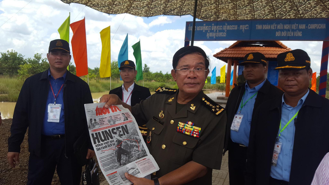 Thủ tướng Hun Sen giơ trang nhất của báo Tuổi Trẻ viết về hành trình tìm đường cứu dân tộc khỏi ách chế độ diệt chủng Pol Pot trong dịp kỷ niệm 40 năm sang Việt Nam tìm đường cứu nước vào tháng 6-2017. Tấm ảnh chụp tại đường biên giới hai nước giữa Bình Phước và Tbong Khnum - Ảnh: VIỄN SỰ