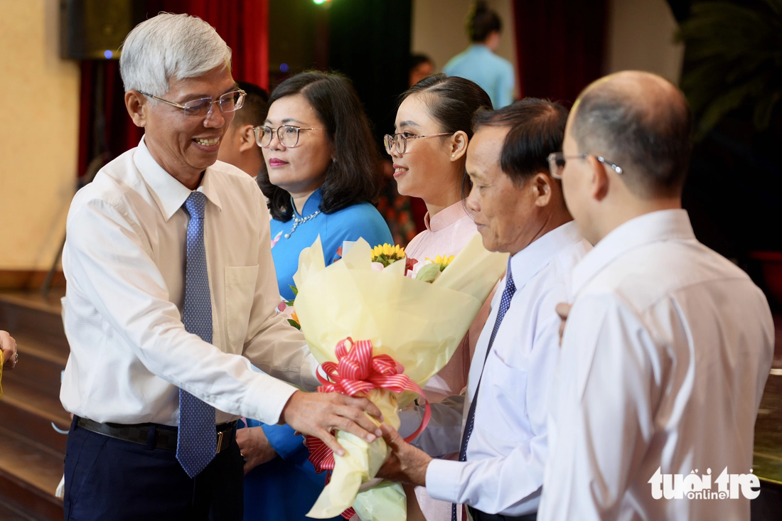 Phó chủ tịch UBND TP.HCM Võ Văn Hoan trao hoa cho các gương điển hình tiên tiến - Ảnh: HỮU HẠNH