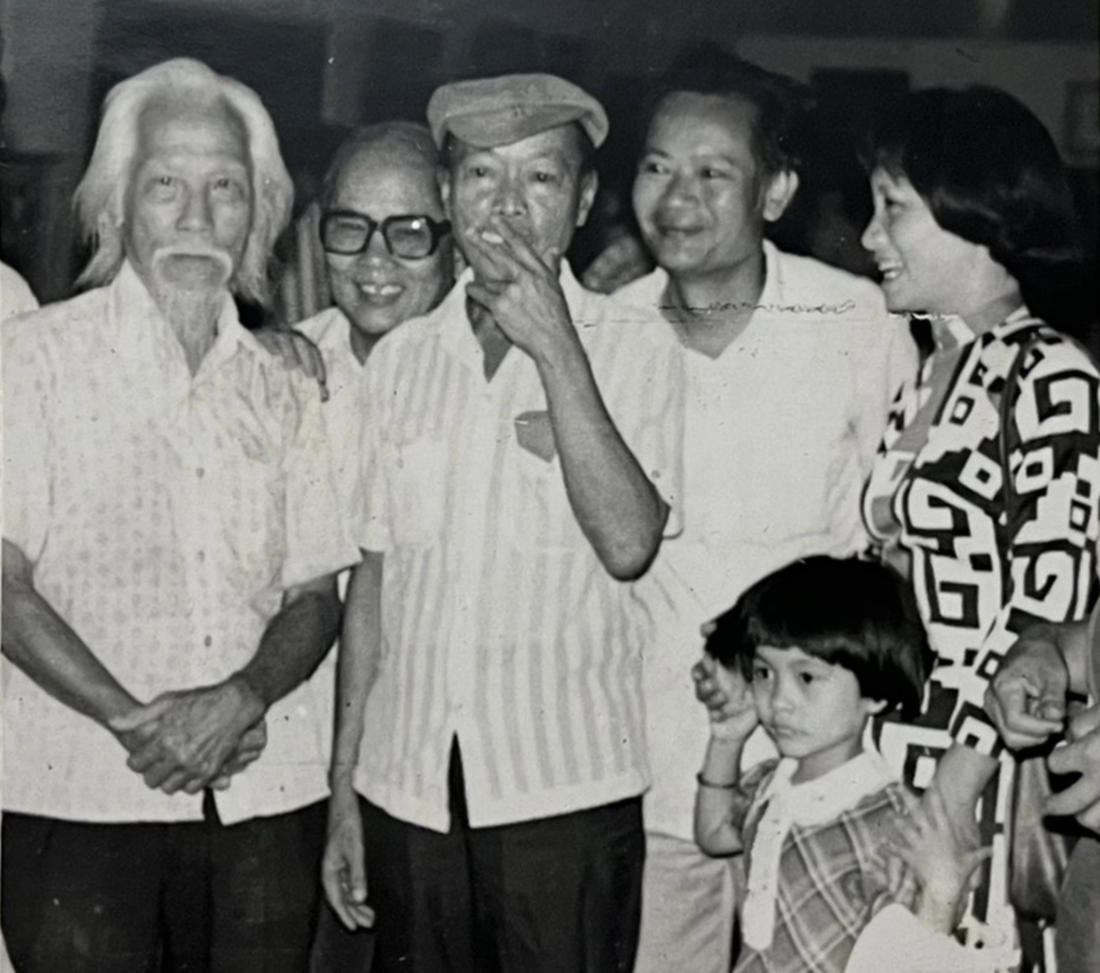 Nguyễn Sáng (thứ hai từ trái sang) và bà Đặng Thị Khuê (bìa phải) với tà áo dài duy nhất trong buổi khai mạc triển lãm của Nguyễn Sáng năm 1984 - Ảnh tư liệu