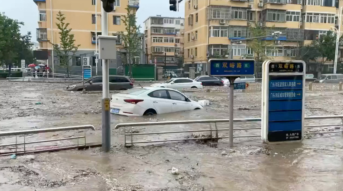 Xe ô tô trong dòng nước lũ tại quận Môn Đầu Câu - Ảnh: REUTERS