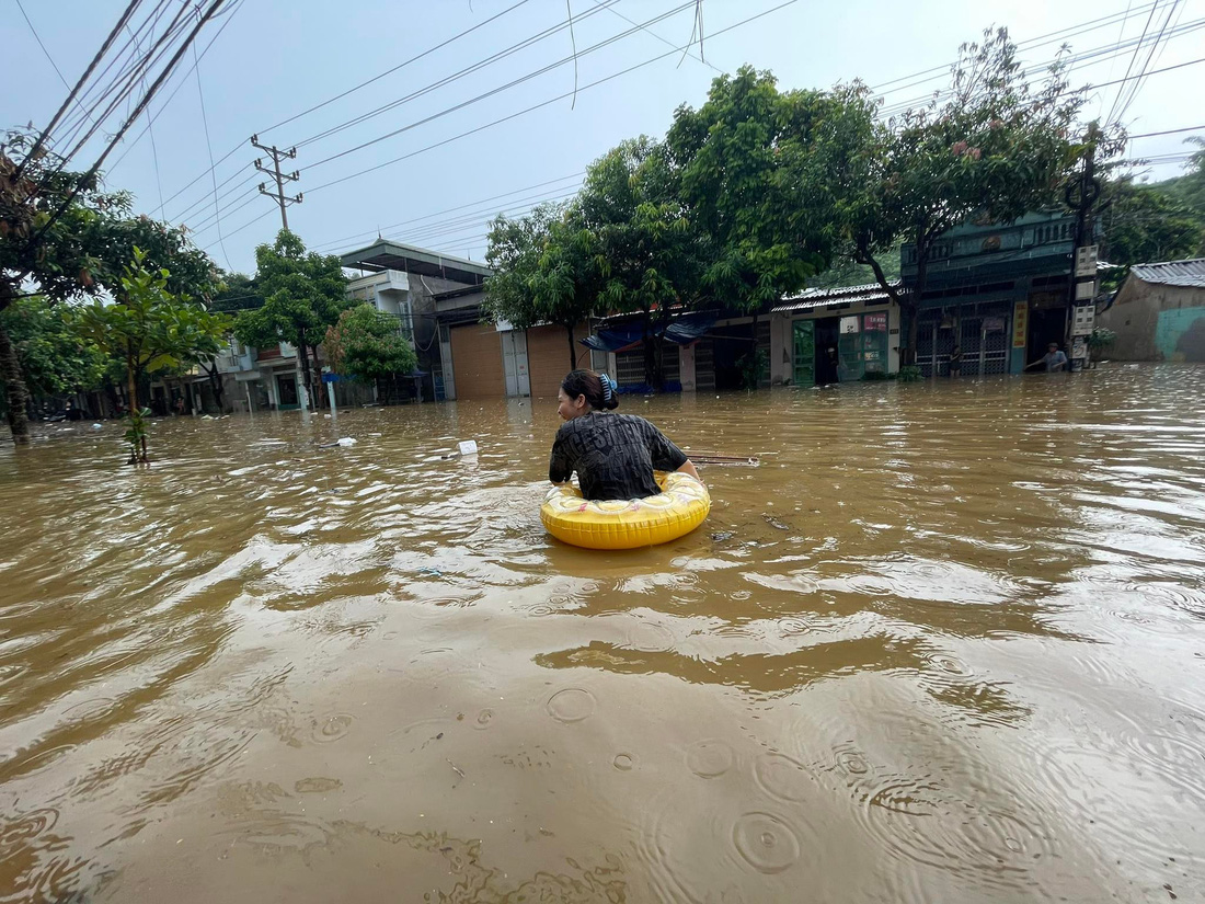 Người dân ở phường Bắc Cường (Lào Cai) dùng phao để di chuyển trên đường - Ảnh: TIẾN NGỌC