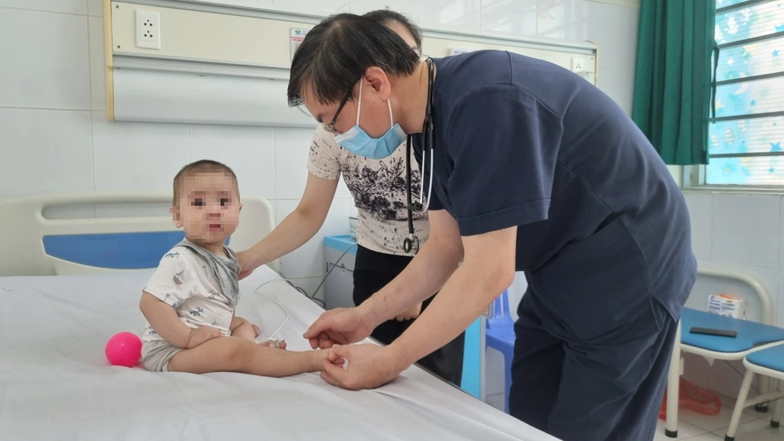 Bác sĩ Bệnh viện Nhi trung ương thăm khám cho trẻ mắc tay chân miệng - Ảnh: DƯƠNG LIỄU