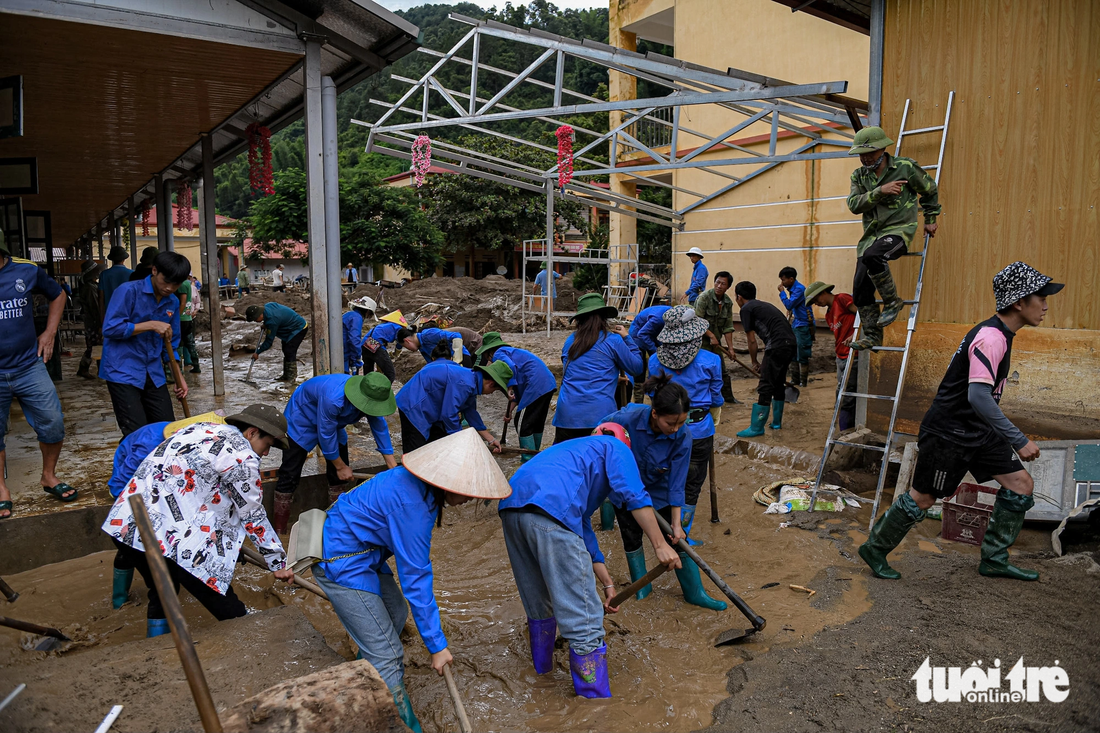 Hàng trăm thanh niên được huy động để khắc phục hậu quả do mưa lũ - Ảnh: NAM TRẦN