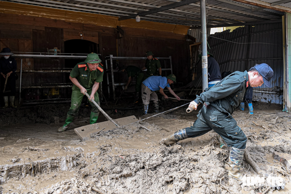 Thanh niên công an, quân đội giúp người dân dọn dẹp nhà cửa - Ảnh: NAM TRẦN