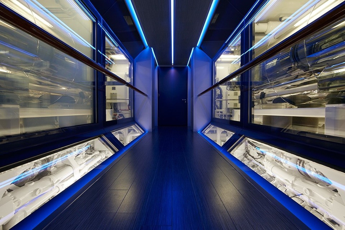 Có một hành lang trang nhã giúp khách có thể nhìn thấy động cơ qua những bức tường kính lớn được chiếu sáng bằng đèn LED màu xanh lam - Ảnh: Feadship