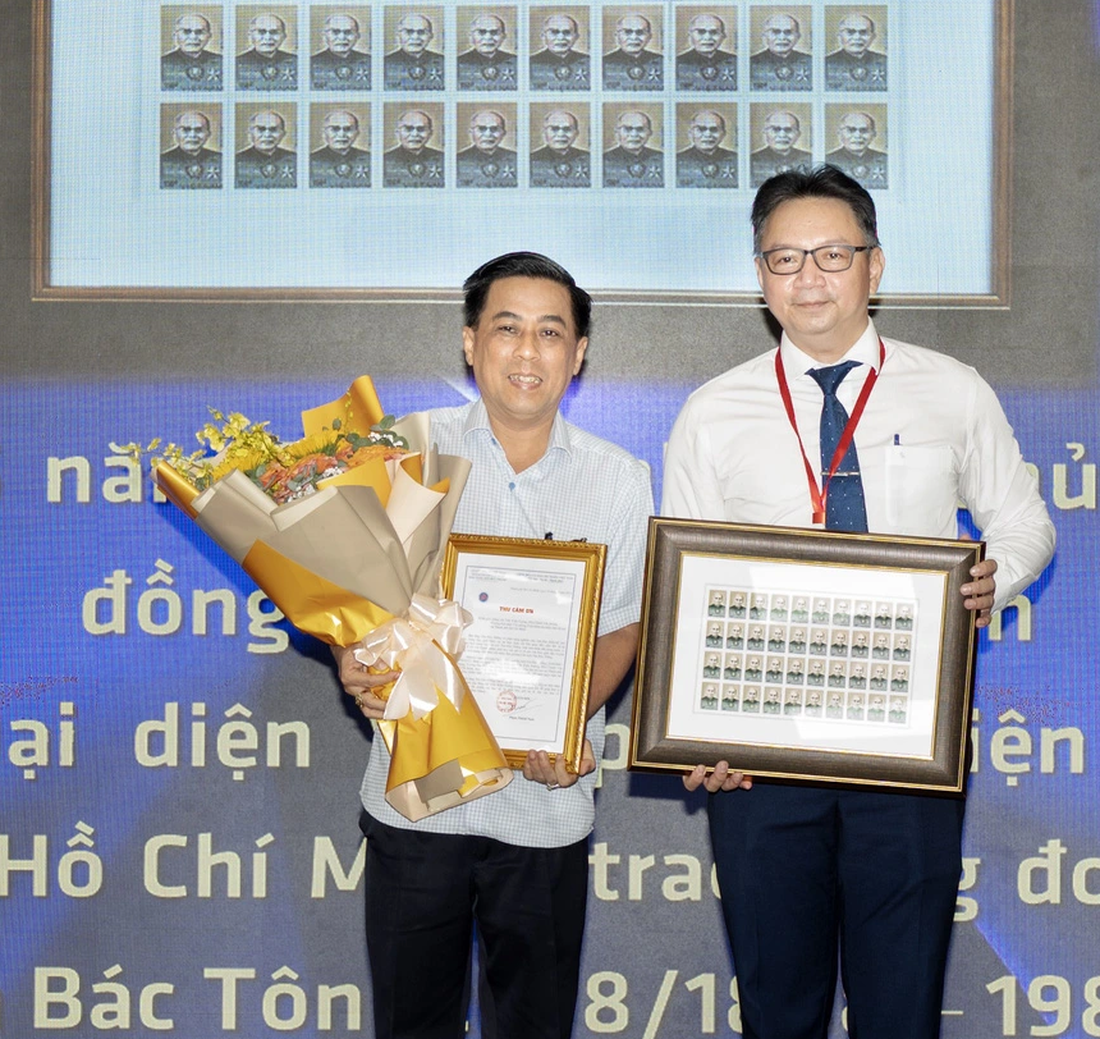Giám đốc Bảo tàng Tôn Đức Thắng Phạm Thành Nam (bìa phải) tiếp nhận bộ tem từ ông Trần Kiến Xương - Ảnh: QUỐC THANH