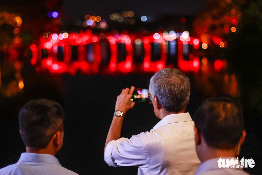 Thủ tướng Lý Hiển Long chụp ảnh cầu Thê Húc dưới ánh đèn vào buổi tối - Ảnh: NGUYỄN KHÁNH