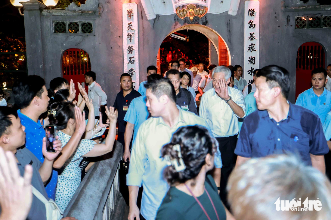 Thủ tướng Lý Hiển Long mỉm cười vẫy tay chào người dân Hà Nội - Ảnh: NGUYỄN KHÁNH