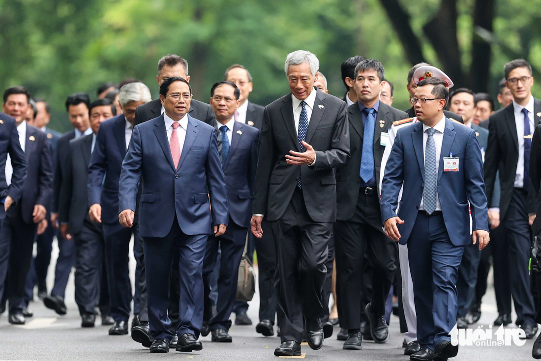 Thủ tướng Phạm Minh Chính và Thủ tướng Lý Hiển Long cùng các quan chức tản bộ đến nơi hội đàm - Ảnh: NGUYỄN KHÁNH