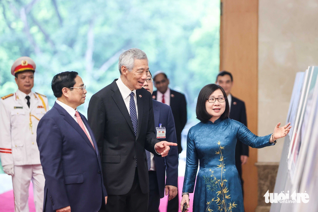 Hai nhà lãnh đạo cùng xem một triển lãm ảnh ngắn về 50 năm quan hệ Việt Nam - Singapore tại trụ sở Chính phủ - Ảnh: NGUYỄN KHÁNH