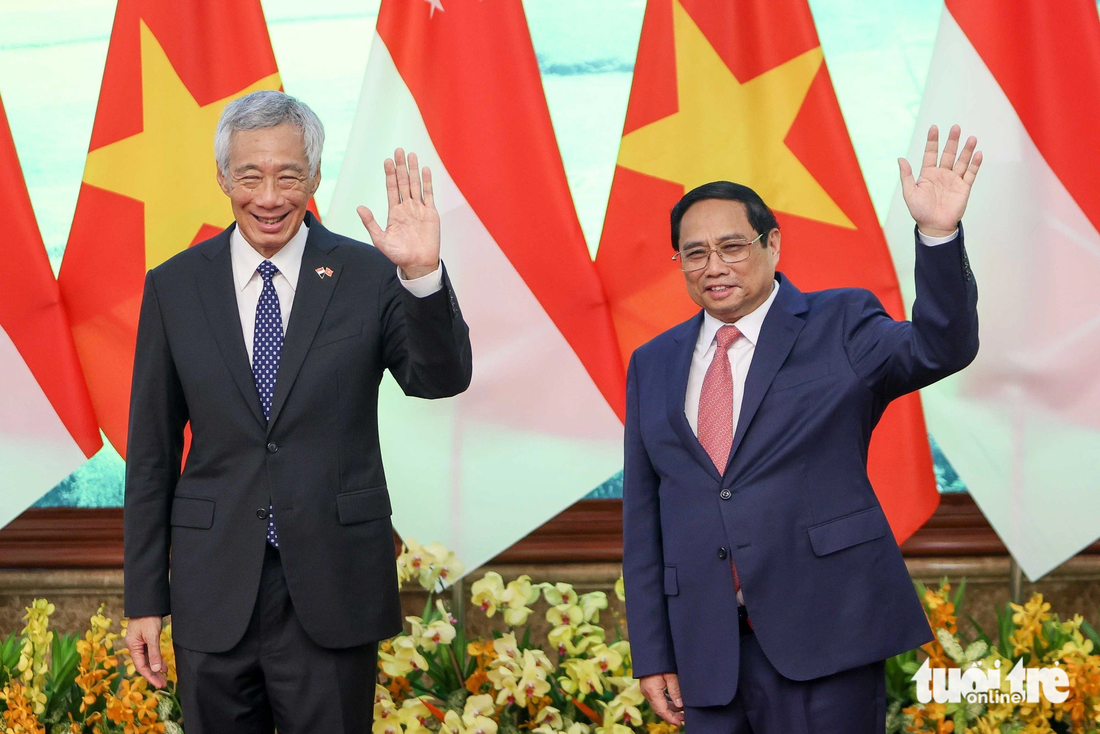 Thủ tướng Phạm Minh Chính và Thủ tướng Singapore Lý Hiển Long vẫy tay chào báo chí trước khi bước vào hội đàm - Ảnh: NGUYỄN KHÁNH