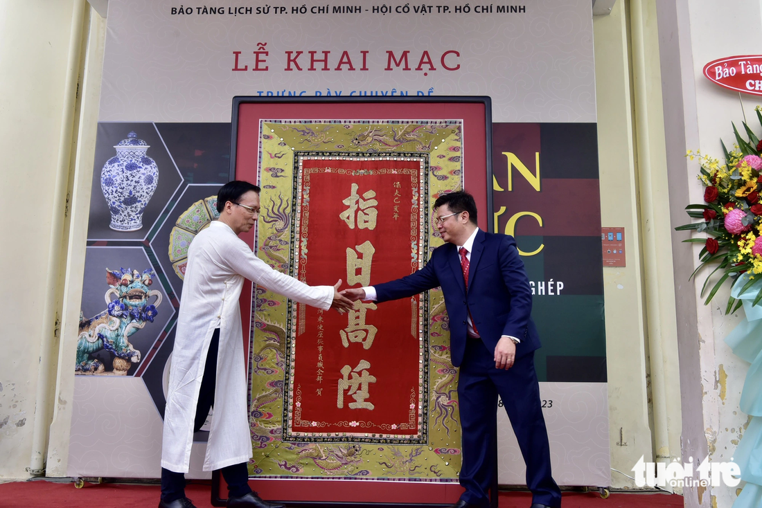 Ông Hoàng Anh Tuấn, giám đốc Bảo tàng Lịch sử TP.HCM (trái), tiếp nhận hiện vật do ông Lê Thanh Nghĩa - chủ tịch Hội Cổ vật TP.HCM - trao - Ảnh: T.T.D.