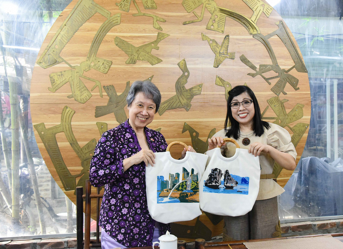 Phu nhân Thủ tướng Phạm Minh Chính và phu nhân Thủ tướng Singapore Lý Hiển Long với thành phẩm là chiếc túi có bức tranh làm từ các mảnh vải vụn được ghép lại - Ảnh: HỒNG NGUYỄN