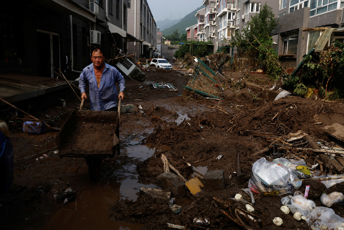 Mưa lũ khiến đường sá ở quận Môn Đầu Câu trở nên nhếch nhác vì bùn đất - Ảnh: REUTERS
