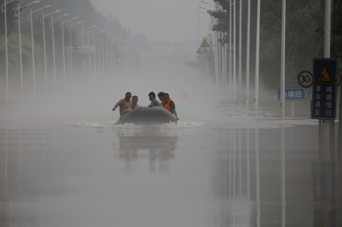 Người dân đi xuồng qua một con đường ngập nước ở thành phố Trác Châu, tỉnh Hà Bắc - Ảnh: REUTERS